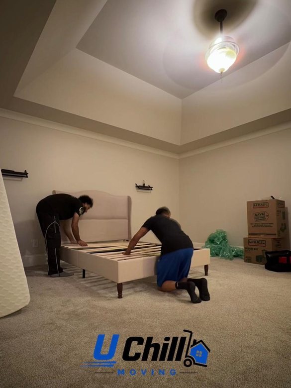 Crew reassembling a bed frame in the new bedroom